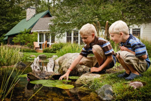 Two boys playing in the creek at the Cottages at Water's Edge,a fractional property at Crystal Mountain